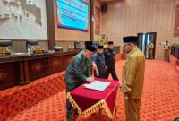 KEBIJAKAN DAERAH: Ketua DPRD Sumenep, Zainal Arifin (kiri) didampingi Bupati Sumenep, Achmad Fauzi Wongsojudo (kanan) saat menandatangani pengesahan raperda di kantor legislatif, Selasa (07/04/2026). (Humas DPRD Sumenep for radarpantura.id)