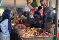 TRANSAKSI: Pedagang daging ayam melayani pembeli di Pasar Anom Baru Sumenep. (Miftahol Rosiqin/Radarpantura.id)