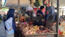 TRANSAKSI: Pedagang daging ayam melayani pembeli di Pasar Anom Baru Sumenep. (Miftahol Rosiqin/Radarpantura.id)