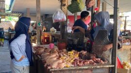TRANSAKSI: Pedagang daging ayam melayani pembeli di Pasar Anom Baru Sumenep. (Miftahol Rosiqin/Radarpantura.id)