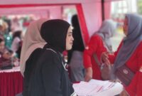 JEMPUT BOLA: Bank Jatim Cabang Sumenep memfasilitasi proses aktivasi akun aplikasi New J-Connect untuk guru di halaman Pemkab Sumenep, Minggu (23/8). (Bank Jatim for Radarpantura.id)